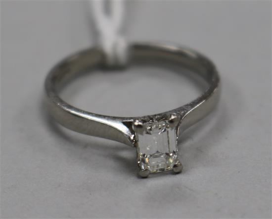 A modern platinum and claw set solitaire baguette cut diamond ring, size L.